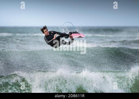 Une action spectaculaire alors qu'un surfeur mâle se balaye à Fistral à Newquay, en Cornouailles. Banque D'Images