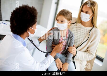 Mère avec sa petite fille à l'examen pédiatre par Femme afro-américaine médecin Banque D'Images