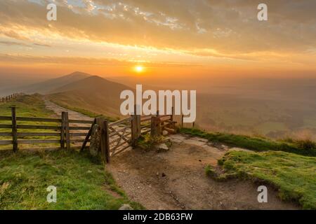 Lever de soleil d'or à MAM Tor dans le Peak District anglais sur un matin d'automne brumeux avec une porte en bois. Banque D'Images