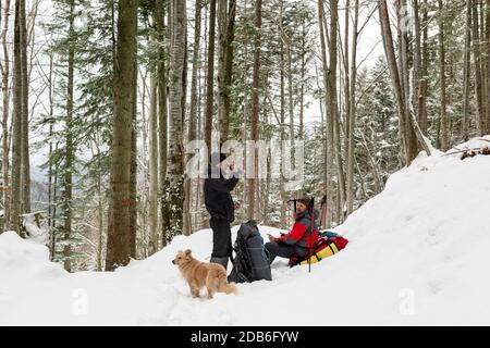 Les touristes avec des sacs à dos se reposer sur une randonnée dans le montagnes d'hiver Banque D'Images