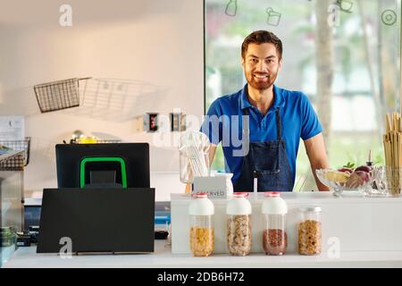 Jeune ouvrier souriant de café Banque D'Images
