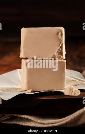 Cubes de levure fraîchement pressés sur une table en bois avec espace de copie. Banque D'Images