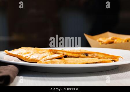 Délicieuse quesadilla mexicaine avec poulet, haricots noirs, fromage et légumes sur la plaque blanche. Prenez la nourriture de rue. Banque D'Images