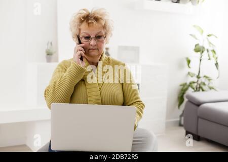 Choqué femme d'âge moyen mature se sentant stressée de lire des nouvelles en ligne incroyables, surprise vieille dame regardant l'ordinateur portable stupéfait par inattendu Banque D'Images