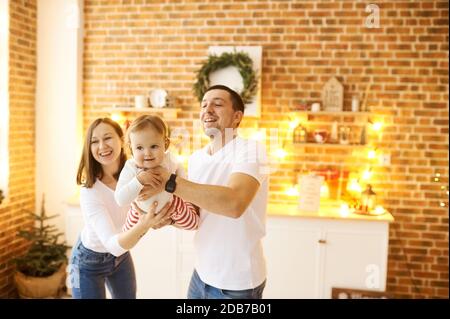 Arrière-plan de Noël. Jeune famille avec un petit enfant s'amuser à Noël à la maison. Banque D'Images