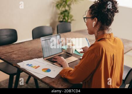 femme d'affaires travaillant sur ordinateur portable au bureau à domicile. Femme utilisant un ordinateur portable à la maison avec quelques documents sur la table. Banque D'Images