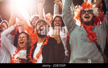 Les fans de football anglais célèbrent la victoire de leur équipe. Les supporters de football d'Angleterre apprécient après une victoire au stade. Banque D'Images