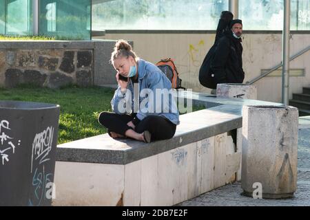 Une jeune femme parle au téléphone près de l'arrêt de tramway Hradcanska pendant la quarantaine. Il s'agit d'une période de confinement en République tchèque en raison de l'incr Banque D'Images