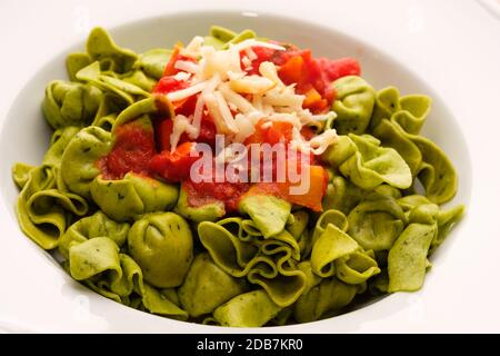 Fagottini vert avec fromage et sauce tomate sur une assiette Banque D'Images