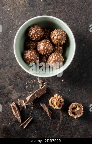 Truffes au chocolat. De savoureuses boules de pralines belges dans un bol sur une table noire. Vue de dessus. Banque D'Images