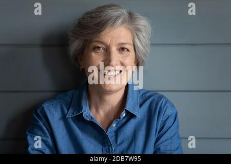 Tête prise de vue portrait sourire gris cheveux femme regardant l'appareil photo Banque D'Images