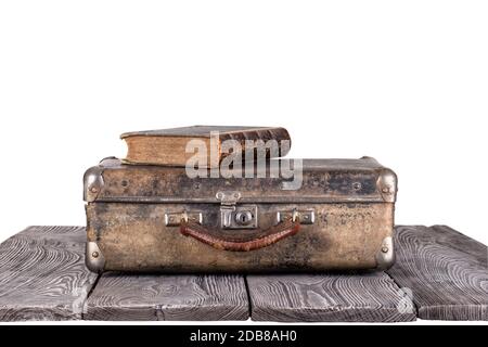 Une vieille valise avec un livre sur les planches de bois. Isolé sur fond blanc. Le concept de voyage dans le temps. Banque D'Images