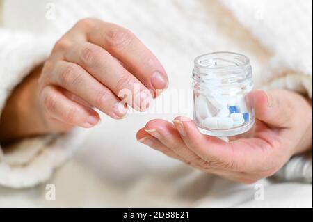Femme âgée qui verse des pilules à partir de la bouteille à la main, vue rapprochée . Banque D'Images