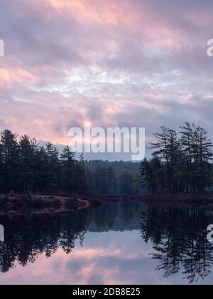 Le soleil se lève au-dessus du lac Tully à Royalston, Massachusetts, lors d'une matinée d'automne brumeuse et trouble. Banque D'Images