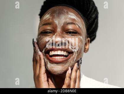 Portrait d'une femme souriante avec un masque facial Banque D'Images