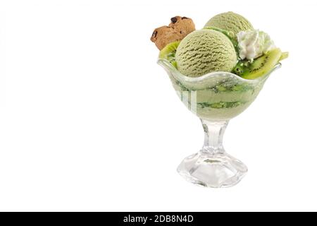 Service de glace crémeuse au kiwifruit faite à la main dans un plat en verre aux fruits frais, une poupée de crème fouettée et un cookie isolé sur blanc avec spac copie Banque D'Images