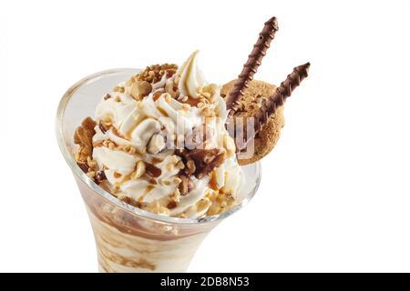 Glace à la vanille avec garniture de noix mélangées hachées garnies de biscuits au chocolat en spirale et d'un cookie isolé sur blanc avec espace de copie Banque D'Images