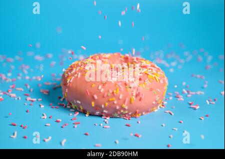 Arroseurs tombant du dessus sur Un Beignet de fraise rose Savoureux. Délicieux dessert sur fond bleu . Banque D'Images