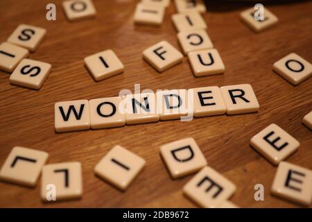 Wonder écrit en carreaux d'alphabet sur une table à Chichester, West Sussex, Royaume-Uni. Banque D'Images