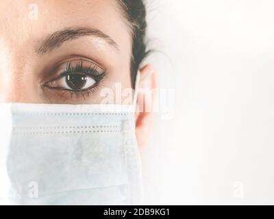 Portrait à moitié face d'une femme médecin dans le masque de protection. Médecin dans un masque médical. Patient, infirmière. Protection contre le coronovirus COVID-19. Copier Banque D'Images