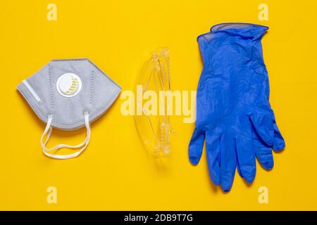 Mesures de protection contre le coronavirus. Gros plan sur un masque facial ou un demi-masque filtrant les particules, des lunettes de sécurité transparentes et des gants médicaux Banque D'Images