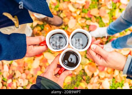 jeunes amis toasting avec café mug portes dans un park.red Et orange humeur.magnifique paysage avec des feuilles jaunes et le feuillage coloré dans la forêt Banque D'Images