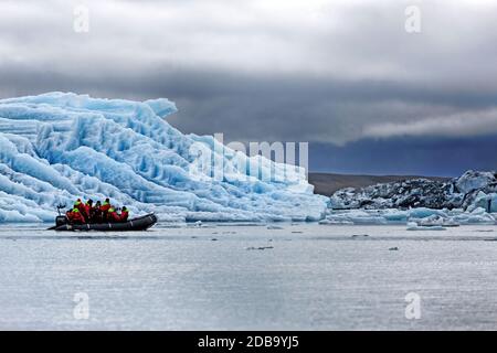 Les touristes dans un bateau en caoutchouc au Glacier Joekulsarlon Lagoon, le sud de l'Islande Banque D'Images