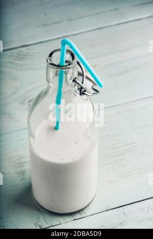 Almand lait dans le flacon en verre avec paille bleu Banque D'Images