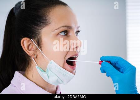 Médecin prenant un échantillon de liquide de bouche de la gorge Banque D'Images