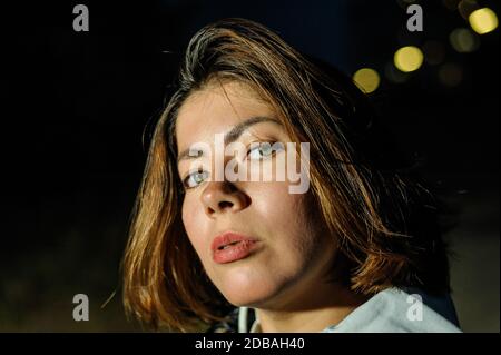 Gros plan portrait du visage d'une belle jeune femme aux cheveux sombres au crépuscule Banque D'Images