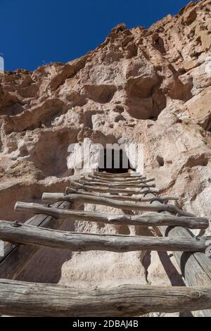 Une échelle en bois mène à une grotte ouvrante sculptée Dans une falaise de grès par le peuple Pueblo à Frijoles Canyon situé à Bandelier National Monumen Banque D'Images