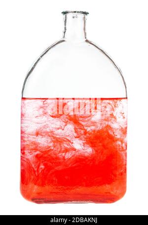le colorant rouge se dissout dans l'eau dans une bouteille isolée sur fond blanc Banque D'Images