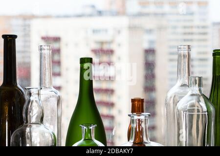 diverses bouteilles vides et vue sur les maisons d'appartement par la fenêtre de maison sur fond Banque D'Images
