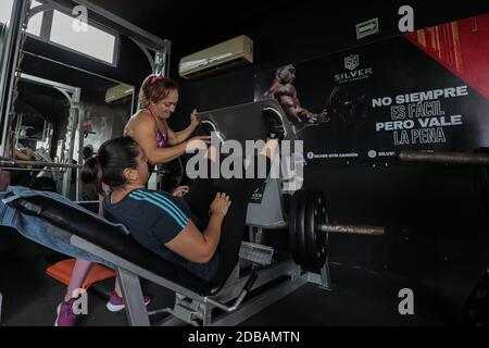 CANCUN, MEXIQUE - NOVEMBRE 16: Entraîneur de fitness Margarita Lopez, soutenir une femme à s'entraîner dans un gymnase dans le cadre de la nouvelle pandémie Covid-19. Margarita a été consacrée pendant deux ans à la formation de personnes dans un gymnase pour soutenir ses trois enfants, l'un d'entre eux avec l'autisme, après que son mari est mort en raison du crime qui a été généré à Cancun; Elle a dû quitter son travail en tant que femme au foyer pour se consacrer à la condition physique et faire face à la crise du coronavirus maintenant sa famille avec ses bénéfices comme entraîneur de fitness. Le 16 novembre 2020 à Cancun, Mexique (photo par Eyepix Group/Pacific Press) Banque D'Images