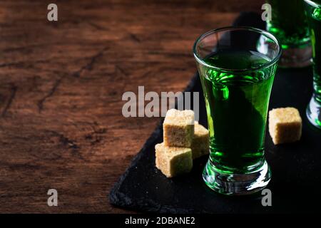 Absinthe - boisson alcoolisée forte, teinture de bois de millepertuis vert amer en verres sur l'ancienne table en bois, place pour le texte Banque D'Images