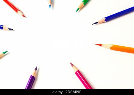 Cercle de crayons de couleur aiguisés. L'accent est mis sur l'espace de copie au centre. Les crayons pointent vers votre texte ou votre idée. Vue de dessus. Banque D'Images