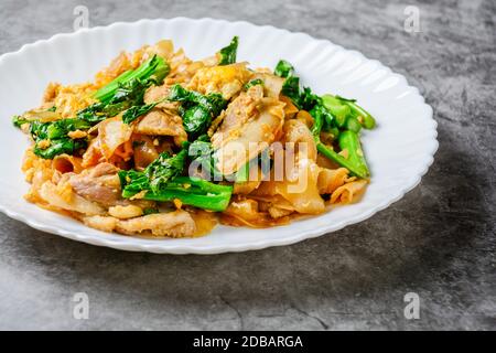 Sauté de nouilles de farine de riz frais avec des tranches de porc, d'oeufs et de chou frisé. Sauté de nouilles rapide. Banque D'Images