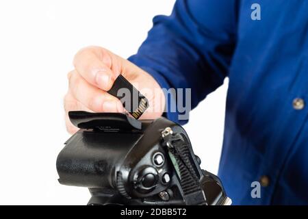 homme insertion d'une carte mémoire dans un appareil photo reflex Banque D'Images