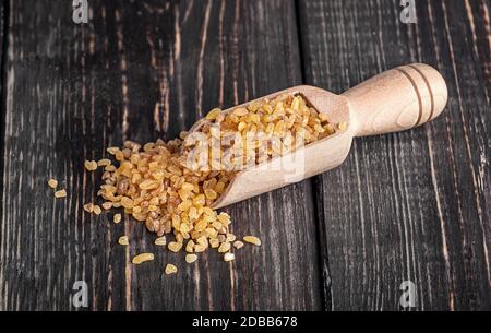 Bulgur en bois sur table sombre Banque D'Images