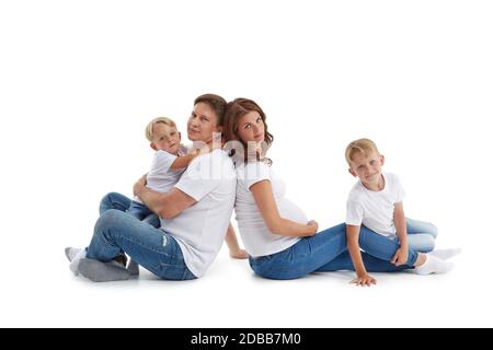 Famille sympathique. La jeune femme enceinte et son mari sont assis avec le dos les uns aux autres avec des enfants, isolés sur un fond blanc. Bon paren Banque D'Images