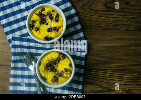 Cocotte de fromage cottage au chocolat et aux myrtilles dans une assiette blanche sur une table en bois. Vues de dessus avec espace libre. Banque D'Images