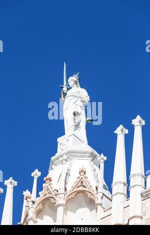 Statue de la déesse de la Justice au sommet du Palais des Doges (Palazzo Ducale) sur la place Saint-Marc, Venise, Italie. Le palais était la résidence du Doge o Banque D'Images