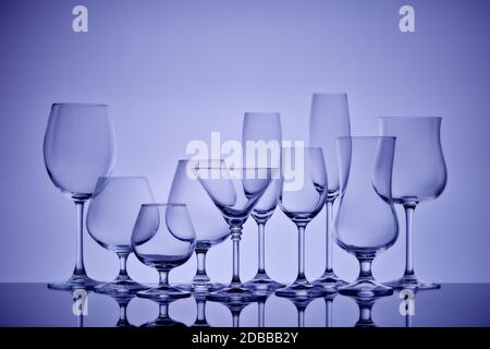 Ensemble de verres pour différentes boissons alcoolisées et cocktails sur fond gris clair. Vider la verrerie transparente. Banque D'Images