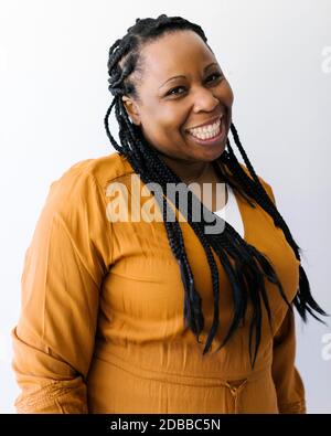 Studio portrait d'une femme souriante tressée Banque D'Images