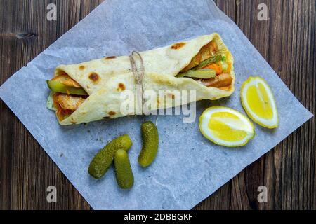 Délicieux kebab de doner turc sur du pain pita grillé rasé viande d'une rôtisserie verticale traditionnelle servie avec une salade fraîche ingrédients sur la rouille Banque D'Images