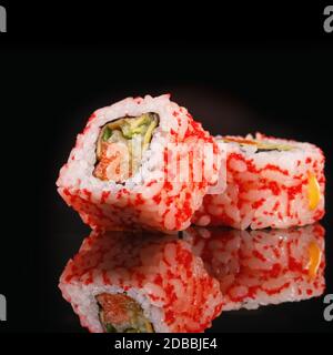 Deux morceaux de sushi se rapprochez sur fond noir. Macro-shot de la nourriture japonaise. Banque D'Images