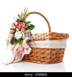 Panier en osier naturel avec fleurs et rubans. Beau noeud sur le côté. Isolé sur un fond blanc Banque D'Images