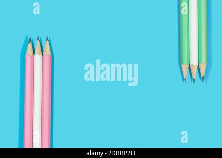 Crayons de rose, blanc et vert sur fond bleu. Papeterie concept Education. Banque D'Images