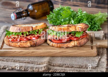 Sandwichs BLT au bacon, à la laitue et aux tomates sur le panneau de bois Banque D'Images
