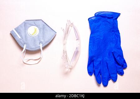 Mesures de protection contre le coronavirus. Gros plan sur un masque facial ou un demi-masque filtrant les particules, des lunettes de sécurité transparentes et des gants médicaux Banque D'Images
